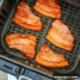 crispy pork belly sizzle to perfection inside an air fryer basket, creating a mouthwatering aroma that promises a delightful crunch.