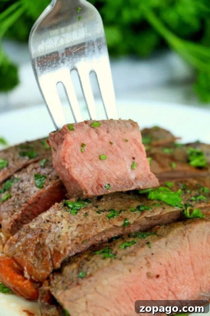 Air Fryer Frozen Steak: Cooked to Perfection 2 Frozen Ribeye steak being cooked in an air fryer basket to a tender, juicy finish.