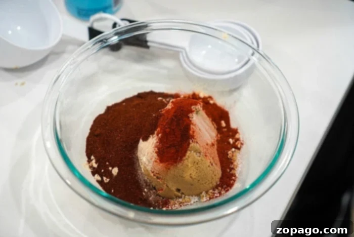Easy No-Thaw Instant Pot Pork Chops 7 A glass bowl filled with spices and brown sugar, perfect for crafting the ideal smoked pulled pork on your Traeger grill, sits at the center, surrounded by measuring cups.