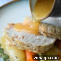 Gravy cascades over sliced roast turkey, carrots, leeks, and thyme, all effortlessly prepared from an Instant Pot frozen turkey breast.
