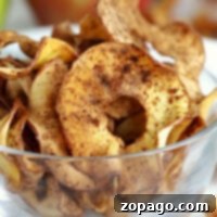 A glass bowl filled with air fryer cinnamon apple chips.
