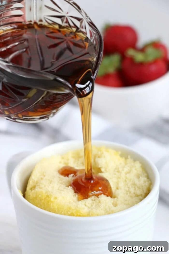 Pancake in a mug, ready to be enjoyed with a drizzle of syrup.