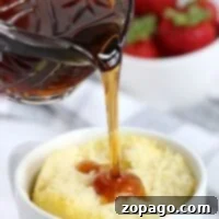Syrup cascades onto a delightful pancake in a mug, with fresh strawberries adding a burst of color in the background.