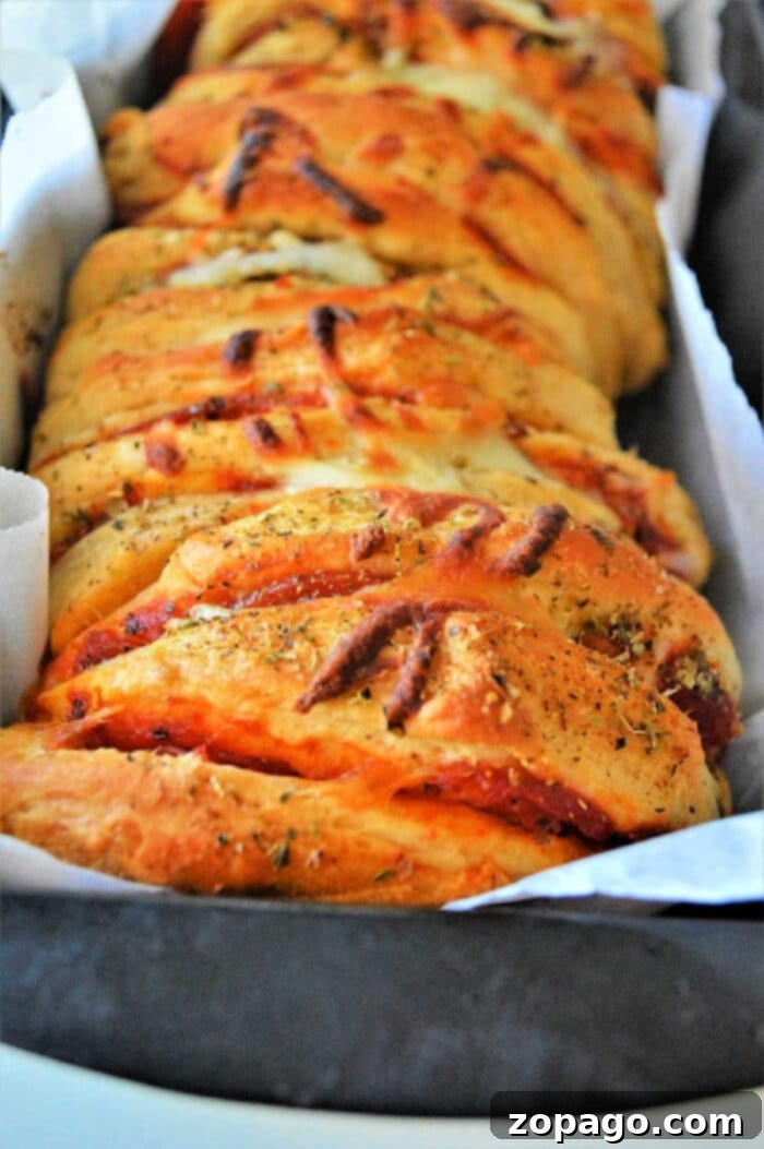 Pizza Monkey Bread 2 Delicious pepperoni pull apart pizza bread made with refrigerated biscuits, ready to be served from a loaf pan.