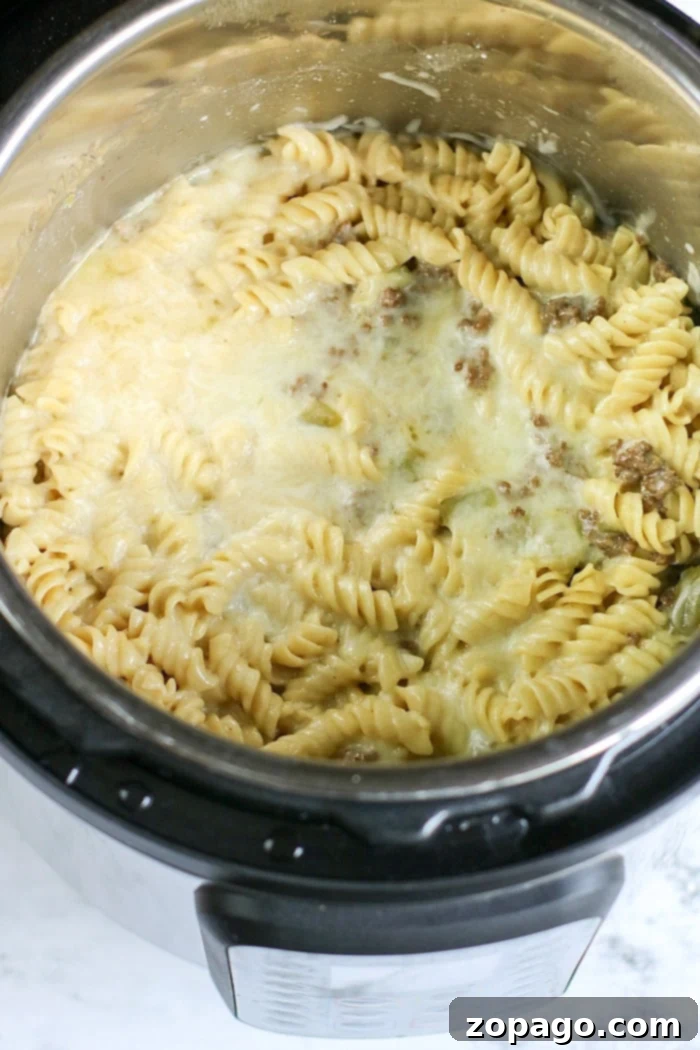 Instant Pot Philly Cheesesteak Pasta 5 Instant Pot ground beef and noodles casserole, close-up with melted cheese and bell peppers.
