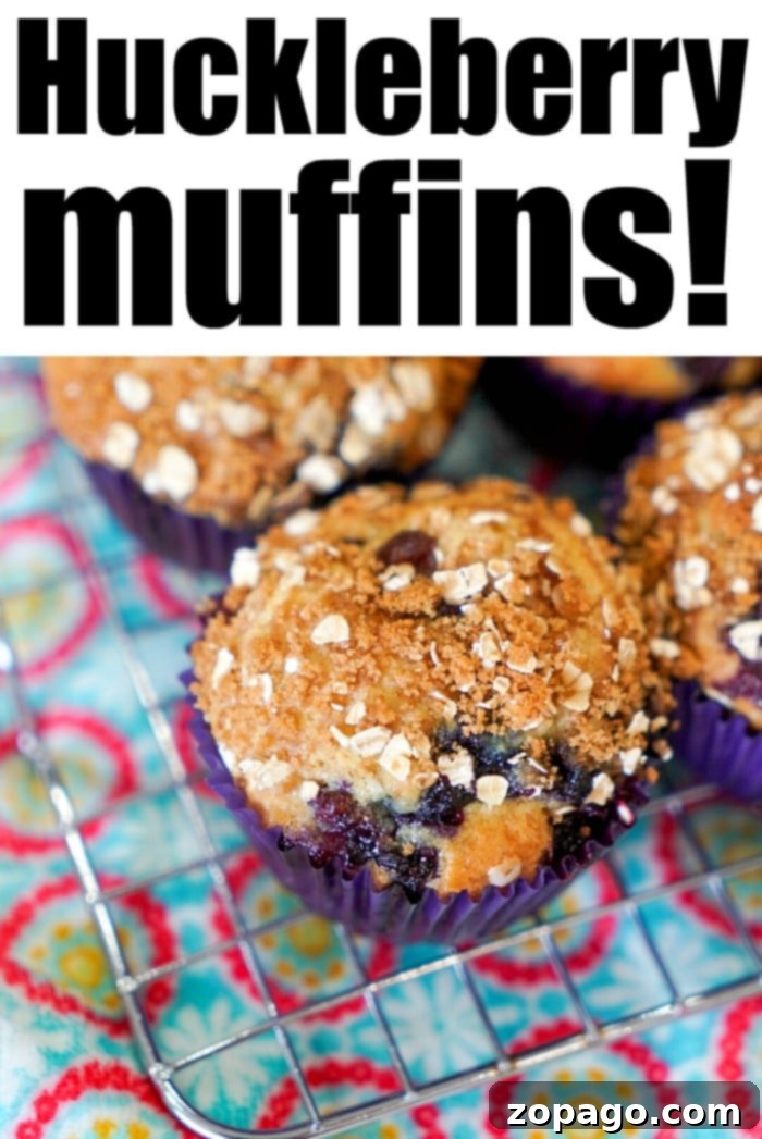 Wild Huckleberry Muffins 7 Close-up of a tray of freshly baked huckleberry muffins with golden crumble tops, ready to serve.