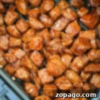Juicy air fryer steak bites sizzle effortlessly in the basket, their seasoned cubes turning golden brown to perfection.