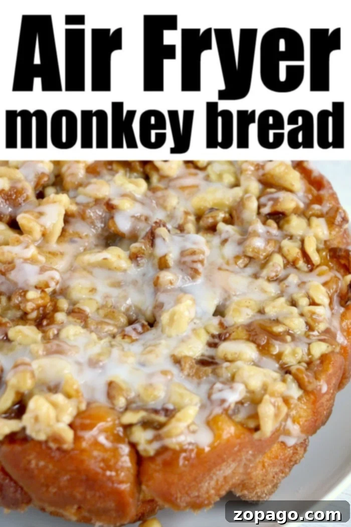 Easy Air Fryer Monkey Bread 7 Close-up of glazed air fryer monkey bread, freshly flipped onto a white plate, with a fork pulling a piece away.
