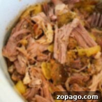 Slow cooker pork shoulder is transformed into tender shredded pork with onions and spices.