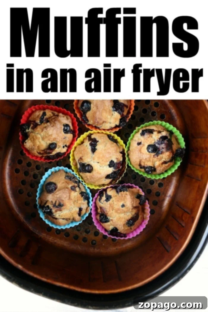 Air Fryer Muffins 5 Perfectly baked muffins in an air fryer basket, ready to be removed