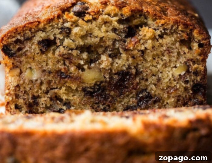 Surprising Mayonnaise Banana Bread 6 A freshly baked loaf of mayonnaise banana bread, sliced to reveal its incredibly moist and tender crumb, resting on a cooling rack.