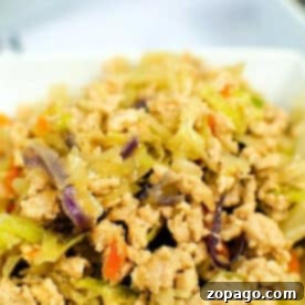 Instant Pot Egg Roll Bowl 5 Instant Pot Egg Roll in a Bowl: Ground chicken stir-fry with shredded cabbage, carrots, and red cabbage, all served in a white bowl.