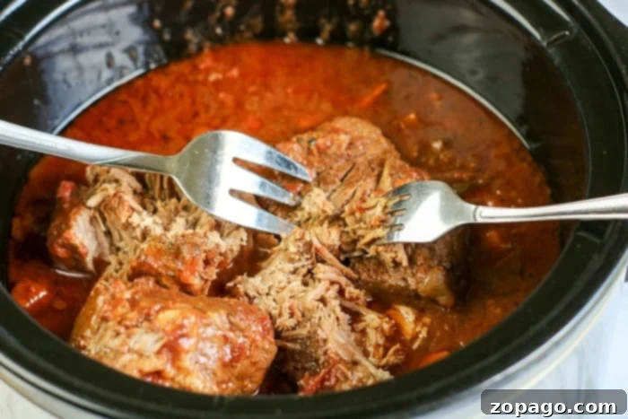 Easy Slow Cooker Spaghetti Sauce 6 Fork-tender pulled beef, fresh from the slow cooker, ready to be mixed into the spaghetti sauce.