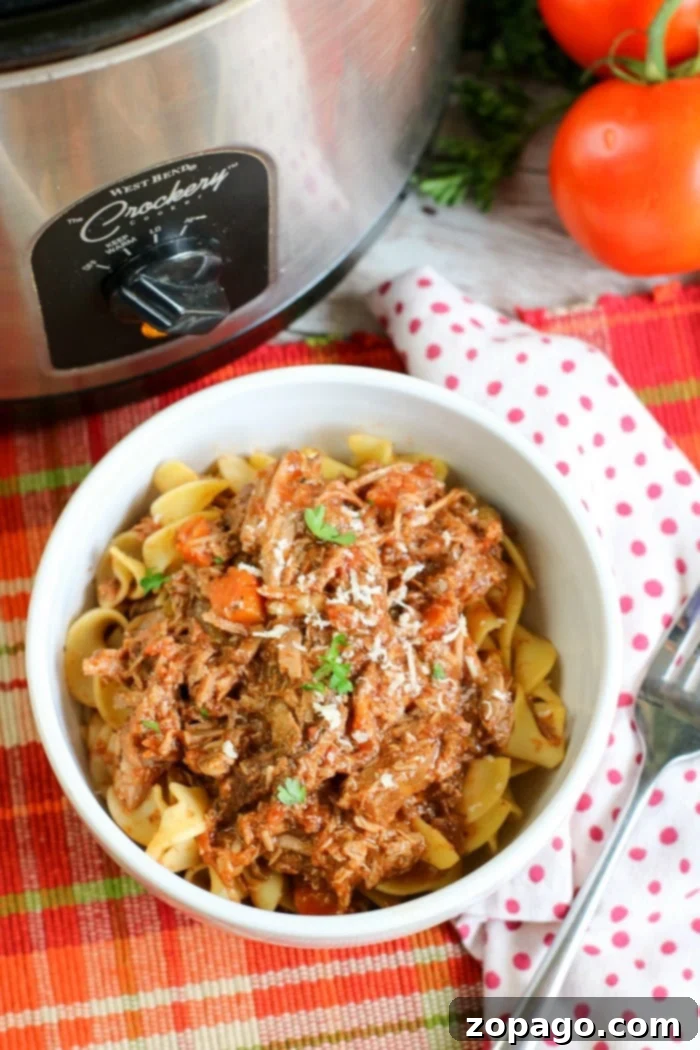 Effortless Slow Cooker Spaghetti 8 Rich slow cooker ragu spaghetti sauce with shredded beef, ready for serving.