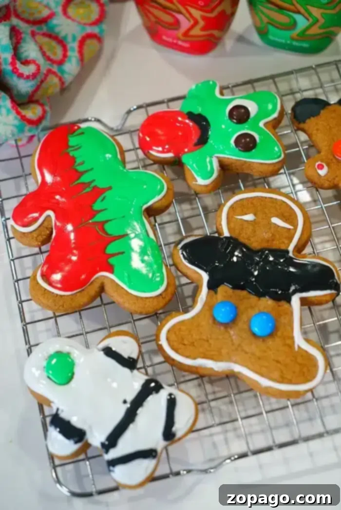 Easy Cake Mix Gingerbread Cookies 2 Colorful, decorated cake mix gingerbread cookies in various shapes rest on a cooling rack, showcasing festive icing and sprinkles.