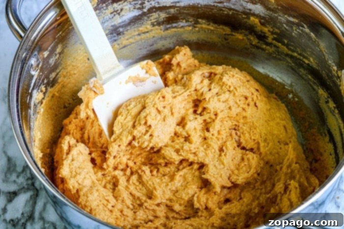 Pumpkin Cinnamon Rolls 4 Pumpkin cinnamon roll dough rising in a bowl, showing its readiness for shaping and baking.