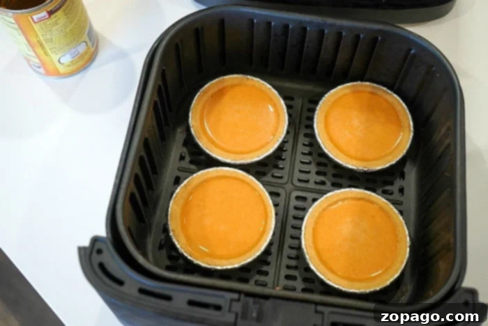 Individual Pumpkin Pie Perfection 6 Two individual pumpkin pies in their foil tins, showcasing their readiness for baking.