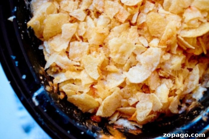 Slow Cooker Comfort Potatoes 6 Close-up of crispy potato chips in a black bowl, reminiscent of the golden topping on crockpot funeral potatoes.
