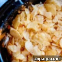 Close-up of crumbled potato chips in a black bowl, reminiscent of the topping on crockpot funeral potatoes.