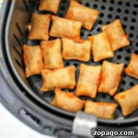 Pizza rolls in the air fryer are arranged in a single layer inside the basket, ready to be cooked to crispy perfection.