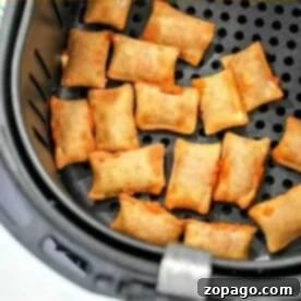 Pizza rolls in the air fryer are arranged in a single layer inside the basket, ready to be cooked to crispy perfection.