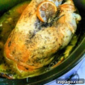 Savor the tenderness of slow-cooked turkey crown, seasoned with herbs and topped with a slice of orange in our easy slow cooker recipe.