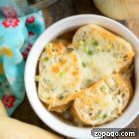 Mastering Delicious Soups in Your Ninja Foodi 10 A bowl of pressure cooker French onion soup, topped with melted cheese and bread slices, sits tantalizingly next to a fresh onion and rustic bread loaf.