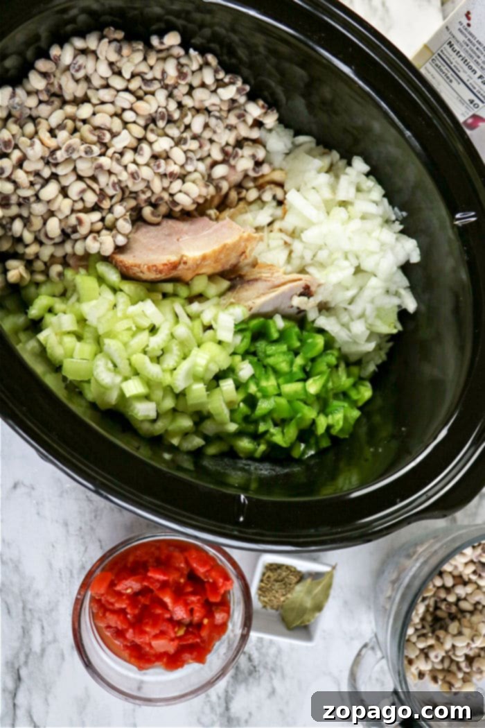 Effortless Slow Cooker Hoppin John 4 A close-up shot of hearty Hoppin' John cooking in a Crockpot, bubbling gently