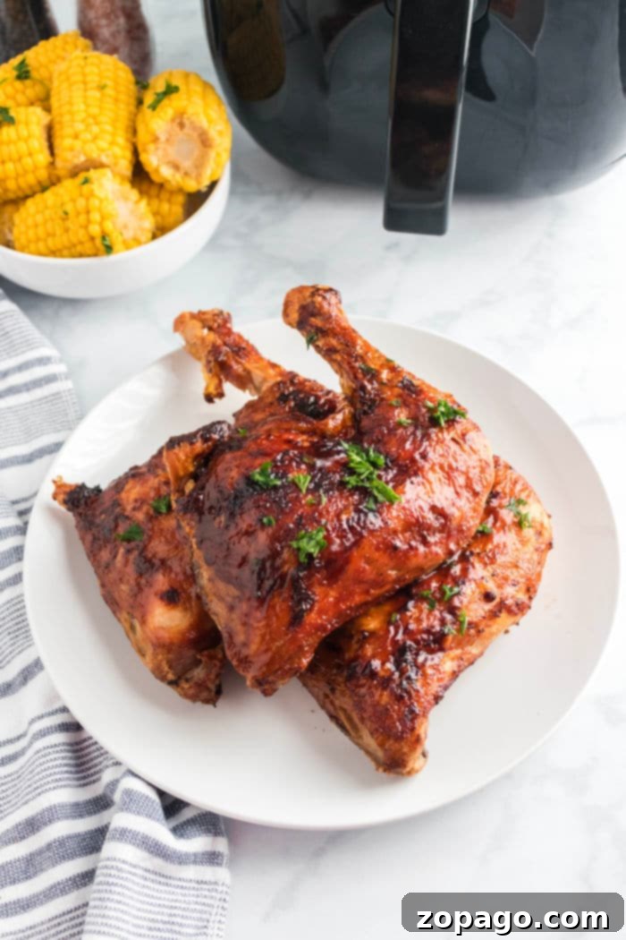 A close-up shot of two crispy Air Fryer Chicken Leg Quarters on a bed of greens.