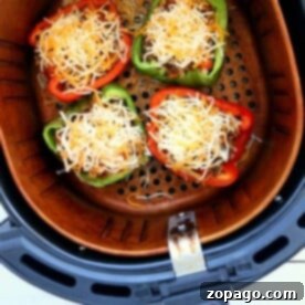 Versatile Ground Beef Recipes 13 Four halved bell peppers filled with ground meat and shredded cheese make delicious air fryer stuffed peppers, arranged perfectly in the air fryer basket.