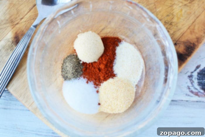 No Thaw Air Fryer Pork Chops 5 Pork chops being coated with a homemade dry rub for enhanced flavor.