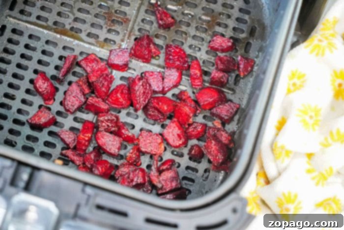 Crispy Air Fryer Beets 6 Cooked, diced beets arranged in an air fryer basket, showcasing their perfectly roasted texture and vibrant color.