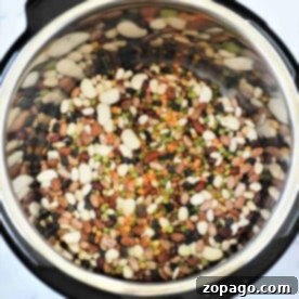 Instant Pot 15 bean soup sits invitingly on a marble countertop, showcasing its hearty mix of flavors and rich textures.