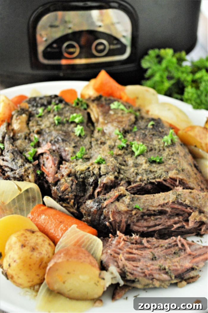 Slow Cooker Frozen Roast 2 Crockpot Roast, a close-up of a slow cooker roast with carrots and potatoes, ready to serve.