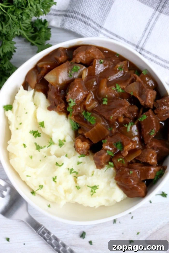 Slow Cooker Frozen Roast 12 Slow cooker beef tips with gravy, green beans, and mashed potatoes on a plate.