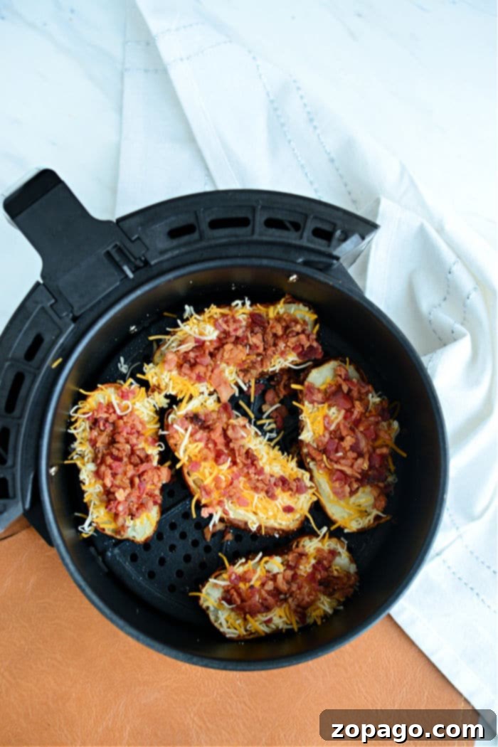 Crispy Air Fryer Potato Skins 6 Air fryer potato skins loaded with melted cheese and crispy bacon bits make for the perfect snack or appetizer, garnished with fresh chives.
