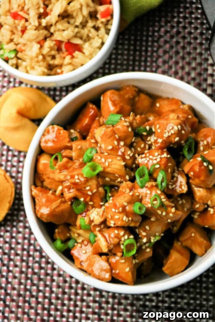 Flavorful Asian Chicken 2 Instant Pot Asian Chicken in a bowl, garnished with green onions and sesame seeds.