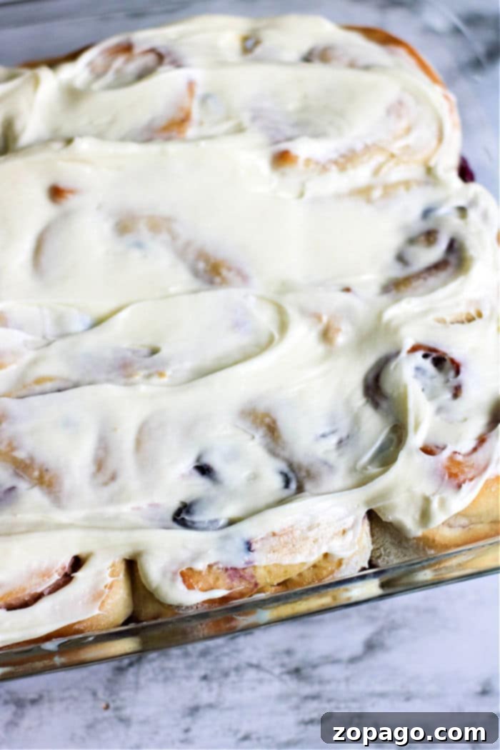 Luscious Homemade Blueberry Sweet Rolls 2 Sweet rolls with a generous layer of white frosting and scattered blueberries, invitingly arranged in a baking dish.