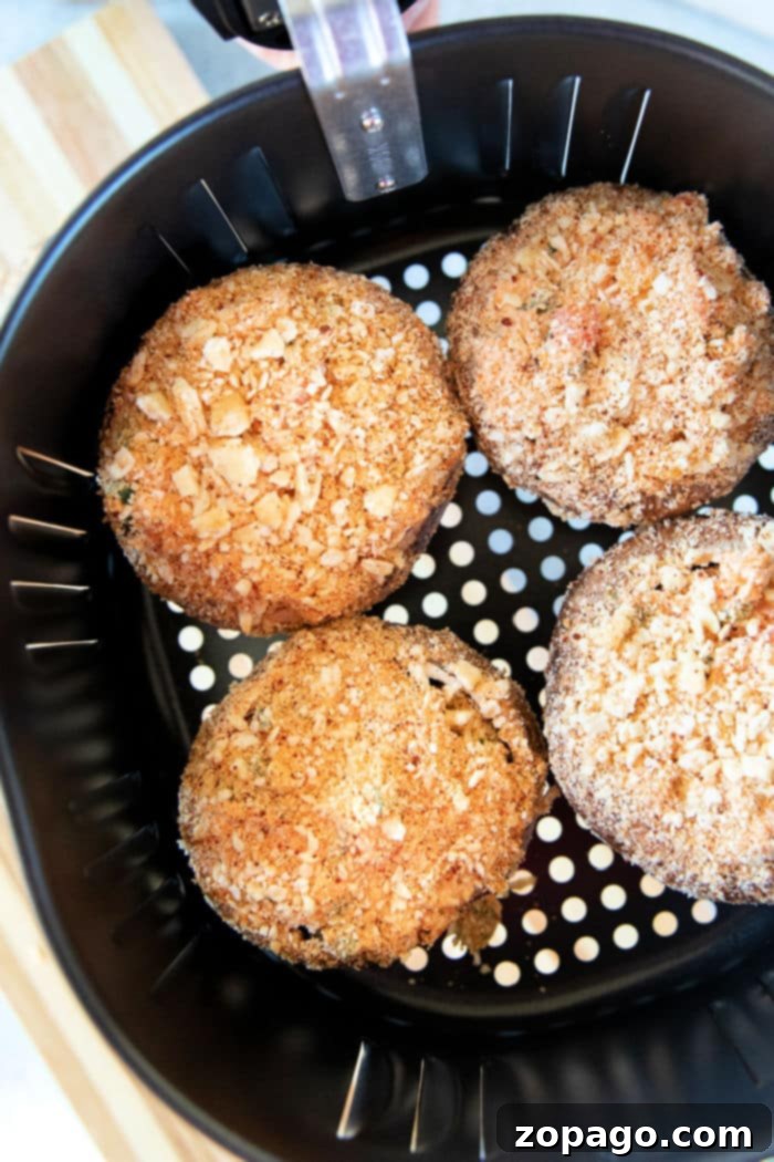 Effortless Air Fryer Stuffed Mushrooms 7 A plate of golden brown air fryer stuffed mushrooms, garnished with fresh parsley.