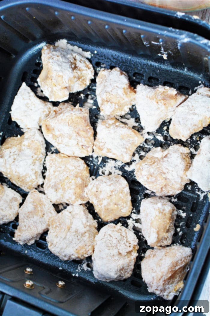 Homemade Crispy Air Fryer Chicken Nuggets 5 Air fryer chicken nuggets with dipping sauce on a wooden board.