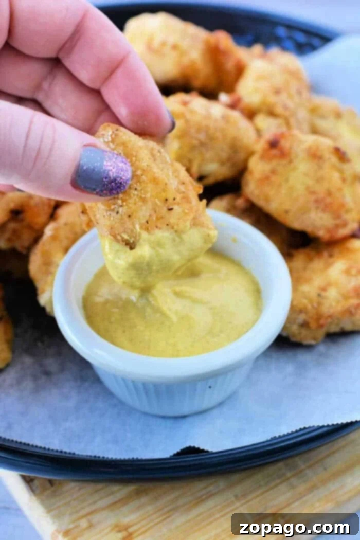 Homemade Crispy Air Fryer Chicken Nuggets 9 A close-up shot of crispy, golden-brown air fryer copycat chicken nuggets on a plate.