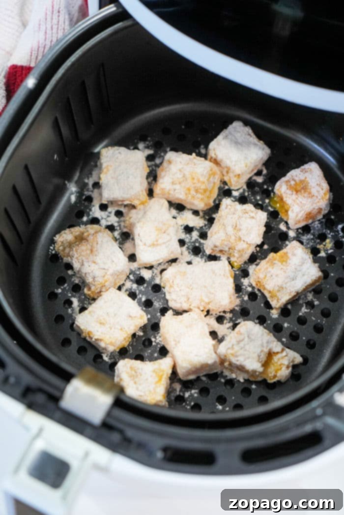 Platter of golden air fryer fish bites with dipping sauce.