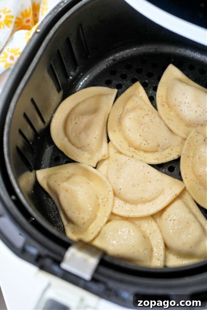 Crispy Air Fryer Frozen Pierogies 7 A close-up shot of golden-brown pierogies perfectly cooked in an air fryer.