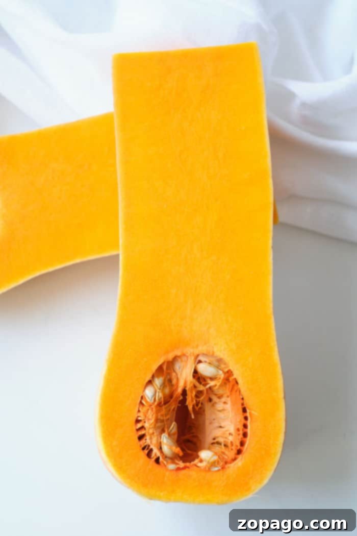 Crispy Air Fryer Butternut Squash 3 A freshly sliced butternut squash, showing its vibrant orange flesh and seeds.