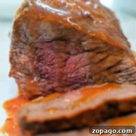 3lb Instant Pot Tri Tip: Tender & Flavorful 7 A close-up of a perfectly cooked tri tip in pressure cooker topped with rich gravy.