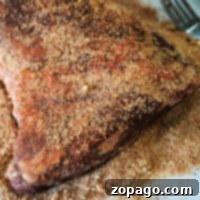 Ultimate Tri-Tip BBQ Blend 8 A seasoned tri-tip, perfectly coated with a flavorful dry rub, rests on a white surface, ready for cooking.