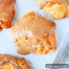 Air Fryer Apple Fritter Perfection 9 Air fryer apple fritters with a delectable cinnamon glaze rest perfectly on parchment paper.