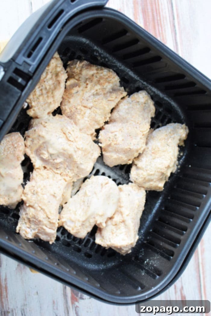 Crispy Air-Fried Chicken Breast 7 Crispy fried chicken in an air fryer basket, showing golden-brown coating