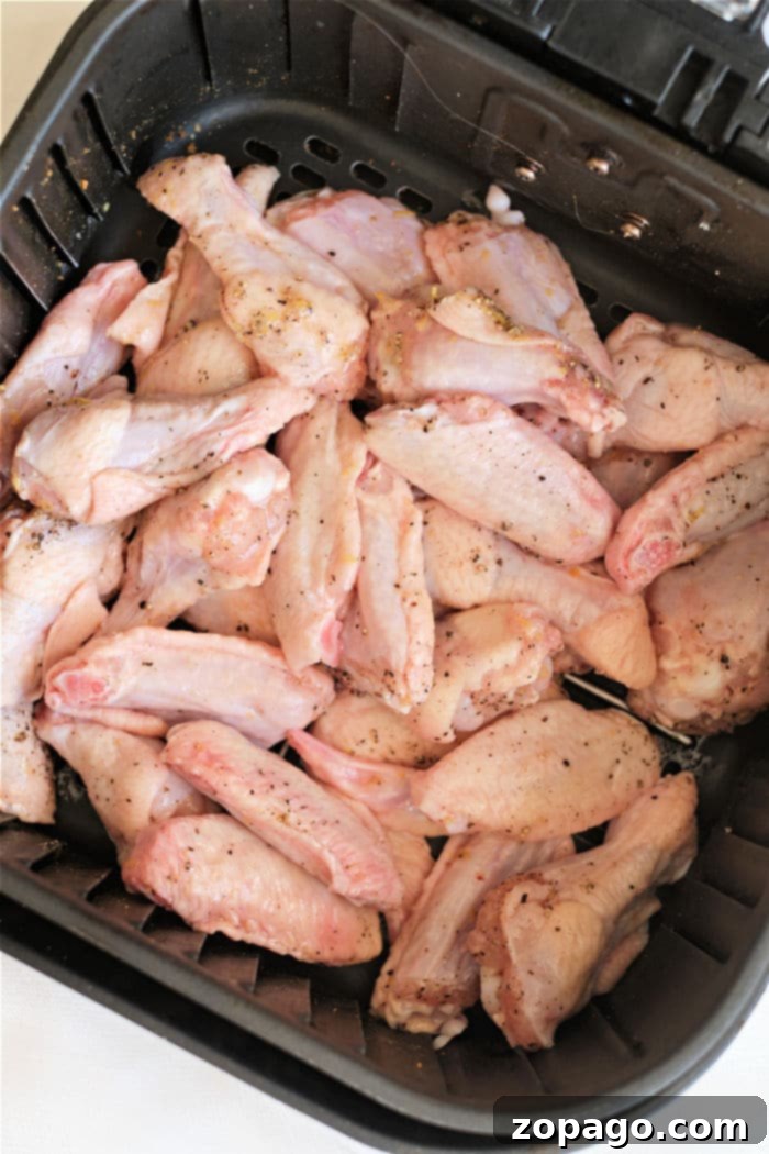 Crispy Air Fryer Lemon Pepper Wings 5 Air fryer basket filled with seasoned lemon pepper chicken wings