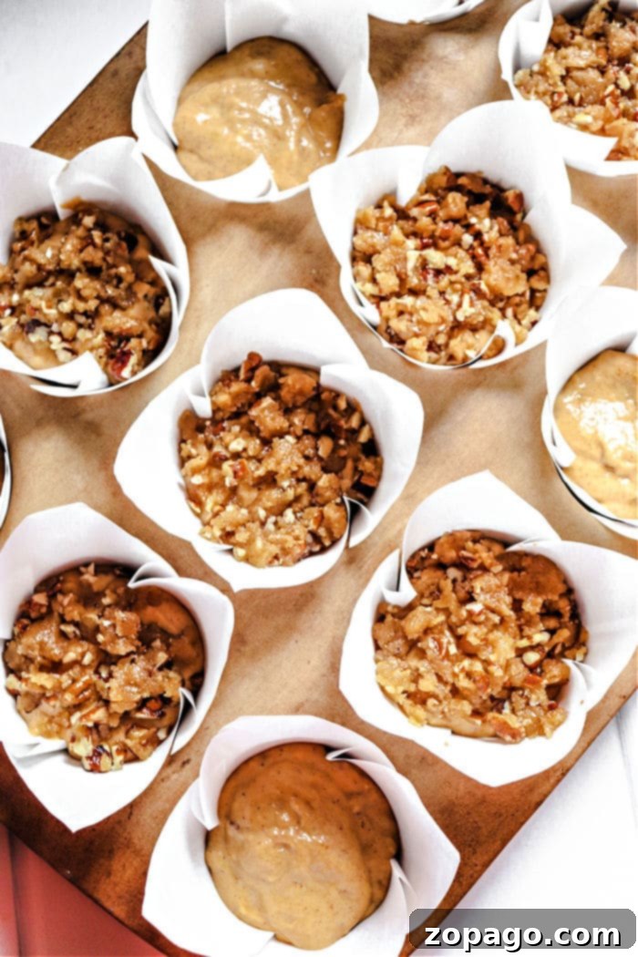 Tiny Pumpkin Banana Muffins 7 A collection of pumpkin crumb muffins, highlighting their textured tops and golden-brown appearance.